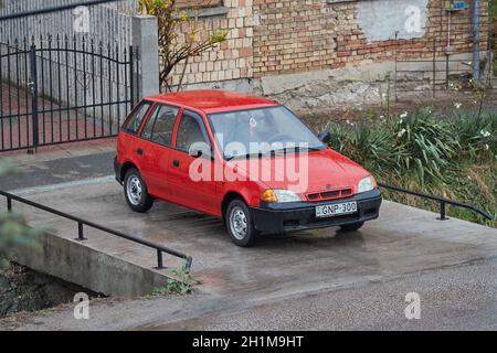 BUDAPEST, UNGARN - UM 2019: Alte Suzuki Swift auf einer Auffahrt geparkt, regnerisches Wetter. Beliebter Kleinwagen, der Anfang der 90er Jahre hergestellt wurde. September 1992 p Stockfoto