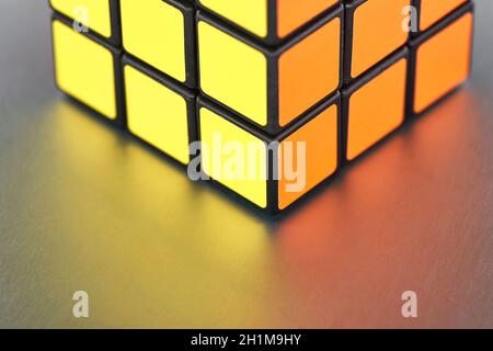 BUDAPEST, UNGARN - UM 2019: Gelöst Rubik's Würfel Logik Spiel untere Ecke auf glänzend reflektierende Metalloberfläche in hellem Licht Stockfoto