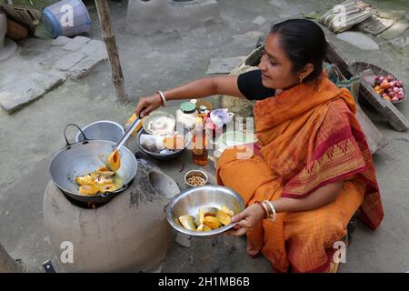 Traditionelle Art der Zubereitung von Essen am offenen Feuer in der alten Küche in einem Dorf, Kumrokhali, Westbengalen, Indien Stockfoto