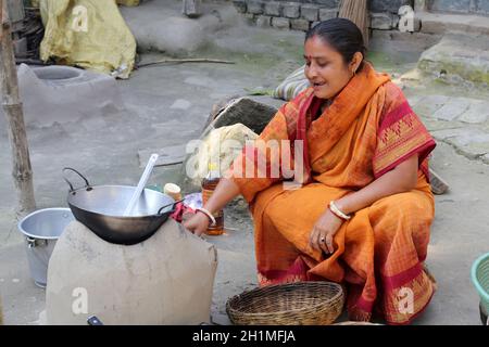 Traditionelle Art der Zubereitung von Essen am offenen Feuer in der alten Küche in einem Dorf, Kumrokhali, Westbengalen, Indien Stockfoto