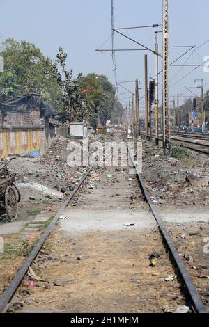 Züge fahren durch die Slums, in denen Menschen unter schwierigen Bedingungen in Titagarh, Westbengalen, Indien leben Stockfoto