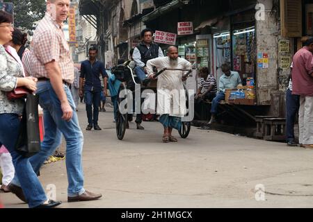 Traditioneller, handgezogener, indischer Rikscha-Fahrer, der auf der Straße in Kalkutta arbeitet Stockfoto