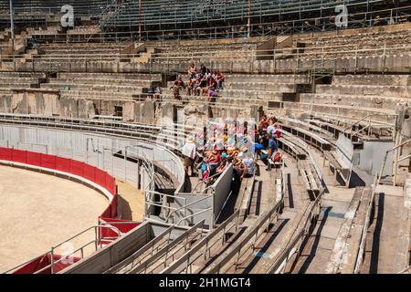 Arles, Frankreich - 19. - 2018. JUNI: Eine Gruppe von Touristen, die sich auf den Stufen des antiken Amphitheaters ausruhen. Stockfoto