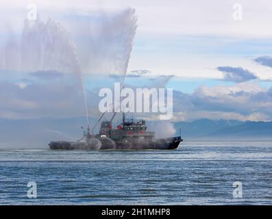 Das schwimmende Schleppboot sprüht Wasserstrahlen Stockfoto