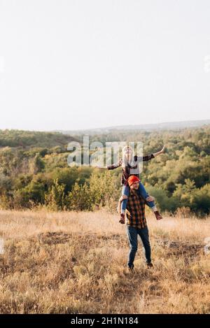 Fröhlicher Kerl und Mädchen auf einem Spaziergang in hell gestrickt Mützen und karierten Hemden Stockfoto