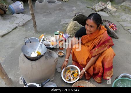 Traditionelle Art der Zubereitung von Essen am offenen Feuer in der alten Küche in einem Dorf, Kumrokhali, Westbengalen, Indien Stockfoto