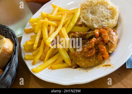 Bratkartoffeln, Sauerkraut, geschmortes Huhn Stockfoto