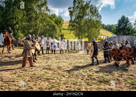 Cedynia, Polen Juni 2019 Historische Nachstellung der Schlacht von Cedynia, Kommandant auf einem Pferd, das eine Verteidigungslinie gegen eine Gruppe von Eindringlingen bildet Stockfoto