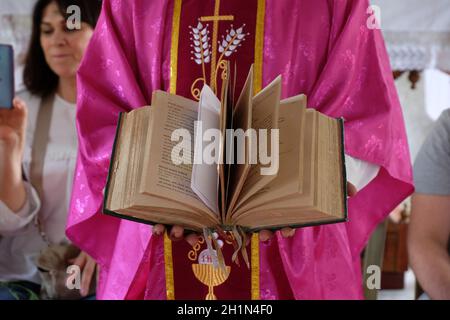 Der Priester hält die missale, katholische Kirche in Chunakhali, Westbengalen, Indien Stockfoto