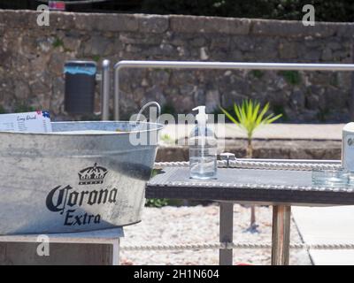 Trough ina Beach Café mit Logo und Inschrift 'Corona Extra' der Biermarke neben Corona Schutzdesinfektionsmittel - Symbolisches Bild Stockfoto