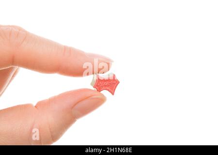 Ecstasy Pille in weiblicher Hand isoliert auf weißem Hintergrund. MDMA unterstützte psychedelische Therapie. Stockfoto