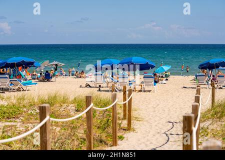 Delray Beach, FL, USA - 17. Oktober 2021: Blaue Sonnenschirme am Strand Stockfoto