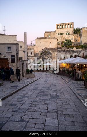 Matera, Italien - 20. September 2019: Abendansicht der Stadt Matera, Italien, mit den bunten Lichtern, die die Patios der Straßencafés im S hervorheben Stockfoto