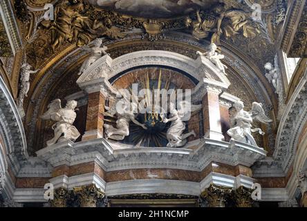 Engel mit einem Globus mit goldenen Strahlen und Initialen IMAS für die Namen Jesus und Maria, Hauptaltar in der Kirche Gesu e Maria in Rom, Italien Stockfoto