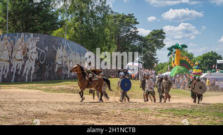 Cedynia, Polen, 2019. Juni Armee von Kriegern, die Festung mit einer Menge Zuschauer im Hintergrund angreifen. Historische Nachstellung der Schlacht von Cedynia dazwischen Stockfoto