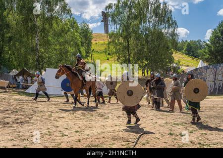 Cedynia, Polen, Juni 2019 Chieftain auf Pferd und seine Krieger attackieren Festung mit Czcibor Berg im Hintergrund. Historische Nachstellung der Schlacht von Stockfoto