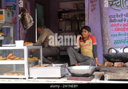 Ein indischer Ladenbesitzer, der in einer Straße in Pushkar, Rajasthan, Indien, gebratenes Street Food verkauft Stockfoto