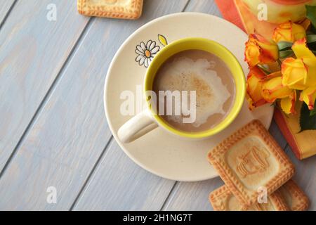 Kaffeetasse mit Frühlingsblumen und Keksen im russischen Stil mit samovaren Noten Guten Morgen auf blauem rustikalem Hintergrund, Frühstück am Muttertag oder Wome Stockfoto