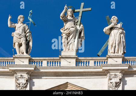 Vatikan, Rom, Italien - 9. Oktober 2020: Figur von Jesus und Apastolen auf der Oberseite der Facada auf blauem Himmel Hintergrund Stockfoto