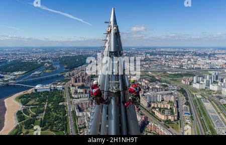 Arbeiter Installateure in der Höhe arbeiten an der Spitze des Wolkenkratzers. Stockfoto