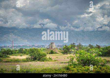 Sandstein St. Nikolaus Kirche mit Dinarischen Alpen im Hintergrund, ist römisch-katholische Kirche in frühromanischer Architektur aus dem 11. Jahrhundert, gelegen sein Stockfoto