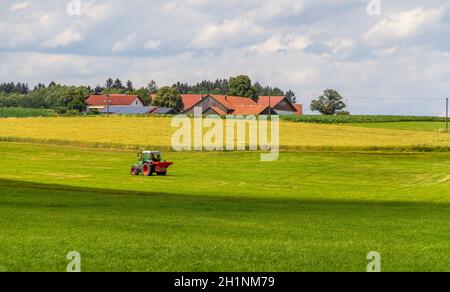 Idyllische ländliche Landschaft mit Traktor rund um Wiesenfelden im Bayerischen Wald im Sommer Stockfoto