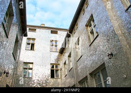 Gebäude mit verspiegelten Wänden. Fassade des Gebäudes aus Spiegelfragmenten. Wände des Hauses sind mit Spiegelstücken bedeckt. Fenster des Gebäudes mit Wal Stockfoto