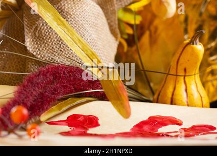 Rote Hand pute auf Vanille-Baupapier und Orangenbeeren Und rot-gelbes Laub neben Quaste und A Gelber Kürbis Stockfoto