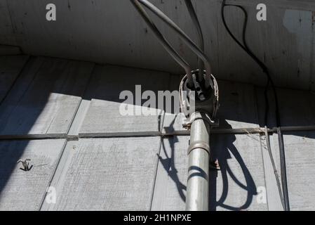 Kabel, die von der Seite eines Hauses hängen Stockfoto