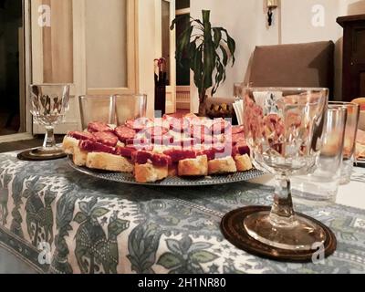 Kaltes Fleisch und alkoholische Getränke am Tisch im leeren Wohnzimmer Stockfoto
