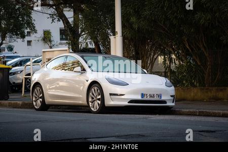 BAYONNE, FRANKREICH - UM JANUAR 2021: Ein weißer Tesla Model 3 parkte auf der Straße. Stockfoto