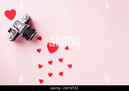 Valentinstag Hintergrund. Vintage retro Kamera und rote Herzen Komposition Grußkarte Liebe Valentinstag Ich liebe Fotografie Konzept auf rosa backg Stockfoto