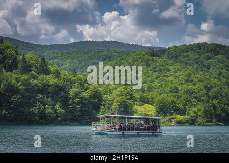 Plitvicka Jezera, Kroatien, Juli 2019 Fähre mit Touristen auf türkisfarbenem See. Nationalpark Plitvicer Seen UNESCO Weltkulturerbe Stockfoto