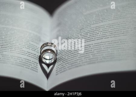 Eheringe liegen im offenen Buch. Stockfoto