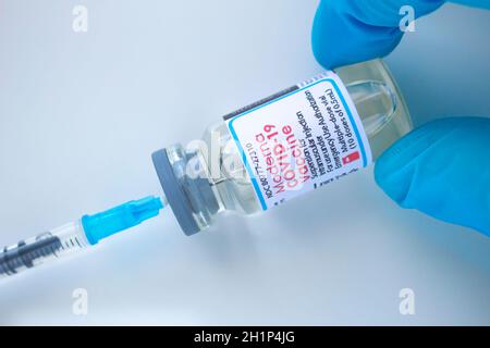 Calgary, Alberta. Kanada. Januar 20 2021. Ein Gesundheitshelfer mit einem Moderna covid-19-Impfstoff und einer Spritze auf weißem Hintergrund Stockfoto