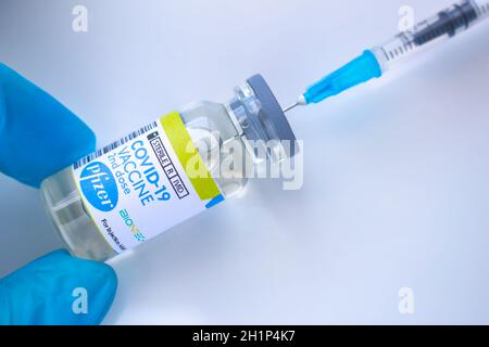 Calgary, Alberta. Kanada. Januar 20 2021. Ein Gesundheitshelfer mit einem Pfizer-Impfstoff und einer Spritze auf weißem Hintergrund Stockfoto