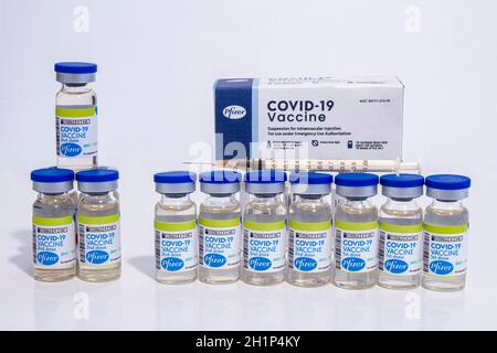 Calgary, Alberta, Kanada. Januar 16, 2021. Mehrere Pfizer Vials Impfstoffflaschen mit Covid-19-Immunisierung mit Packungsbox und einer Injektionsspritze auf einem Stockfoto