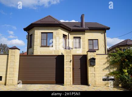 Dekorative auf dem Dach eines Brick House. Zaun aus Wellblech Stockfoto