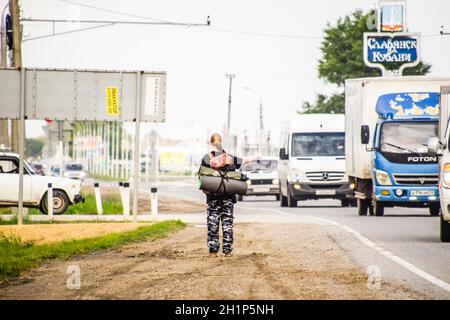 Krasnodar, Russland - 1. Juni 2017: Per Anhalter. Mädchen Auto - Stopper. Das Mädchen mit dem Rucksack hält das Auto. Abstimmung über den Track. Stockfoto