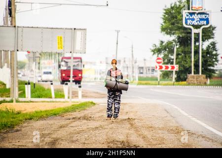 Krasnodar, Russland - 1. Juni 2017: Per Anhalter. Mädchen Auto - Stopper. Das Mädchen mit dem Rucksack hält das Auto. Abstimmung über den Track. Stockfoto