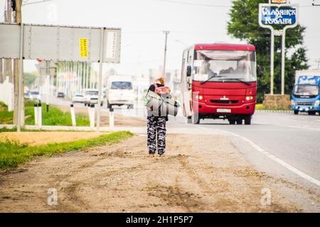 Krasnodar, Russland - 1. Juni 2017: Per Anhalter. Mädchen Auto - Stopper. Das Mädchen mit dem Rucksack hält das Auto. Abstimmung über den Track. Stockfoto