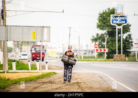 Krasnodar, Russland - 1. Juni 2017: Per Anhalter. Mädchen Auto - Stopper. Das Mädchen mit dem Rucksack hält das Auto. Abstimmung über den Track. Stockfoto