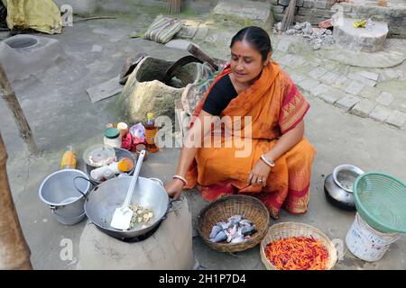 Traditionelle Art der Zubereitung von Essen am offenen Feuer in der alten Küche in einem Dorf, Kumrokhali, Westbengalen, Indien Stockfoto