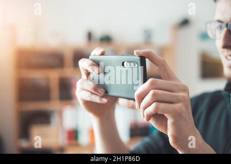 Nahaufnahme der schwarzen Smartphone-Kamera, aufnehmen und aufnehmen von Bildern in Innenräumen. Content-Produktion. Stockfoto