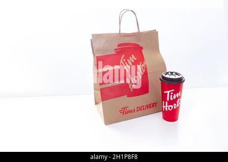 Calgary, Alberta. Kanada. Januar 25 2021. Eine Tim Horton Lieferpapiertasche und eine Kaffeetasse auf weißem Hintergrund. Stockfoto