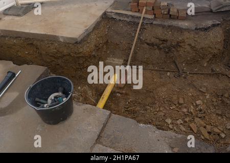 Arbeiten an der Installation von Engineering- und Heizsystemen. Zwei Kunststoffrohre, eine gelbe für Gasleitung und eine schwarze für Stromleitungen. Sie befinden sich in einer SA Stockfoto