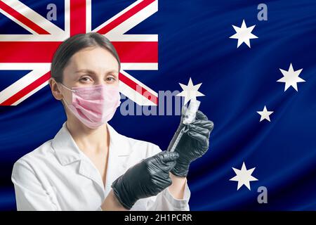 Die Ärztin bereitet die Impfung vor dem Hintergrund der australischen Flagge vor. Impfkonzept Australien. Stockfoto