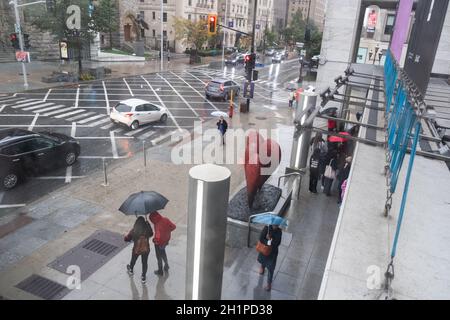 Fußgänger flanieren an einem regnerischen Tag auf der Sherbrooke Street in Montreal, Quebec, Kanada, in der Nähe des Montreal Museum of Fine Arts Stockfoto