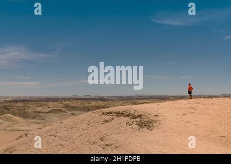 Unbekannte Person schaut in die Mondlandschaft bei Swakopmund, Namibia Stockfoto