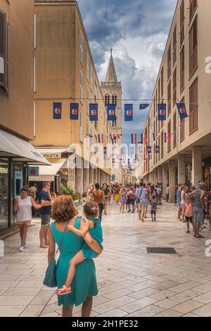 Zadar, Kroatien, Juli 2019 Touristen besuchen schöne Straßen der Altstadt mit Glockenturm der St. Donata Kirche im Hintergrund Stockfoto